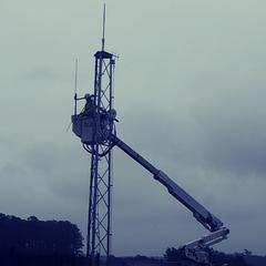 Man in cherrypicker at tower