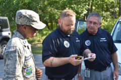 3 cap members look at phone