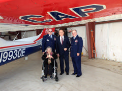 Congressional Gold Medal recipients Lt Col Clive Goodwin, Jr. CAP and 2nd Lt Annie Stevenson Hyde, CAP show their medals while standing with Col Larry Ragland, CAP National Executive Officer and Col David Crawford, CAP besides a Civil Air Patrol airc