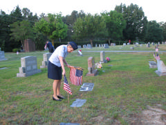 Members of the Orange County Comp Squadron place flags on veterans’ graves at the Chapel Hill Memorial Cemetery