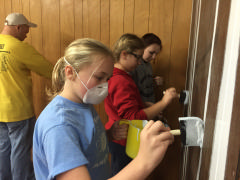 Cadet Regan Lavinder, C/Amn Sarah Benson, and C/Amn Marissa Haskell paint the seams in the paneling.